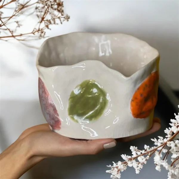 Pot décoratif haute gamme en céramique fait main. Blanche avec de reliefs colorés en forme de feuille.